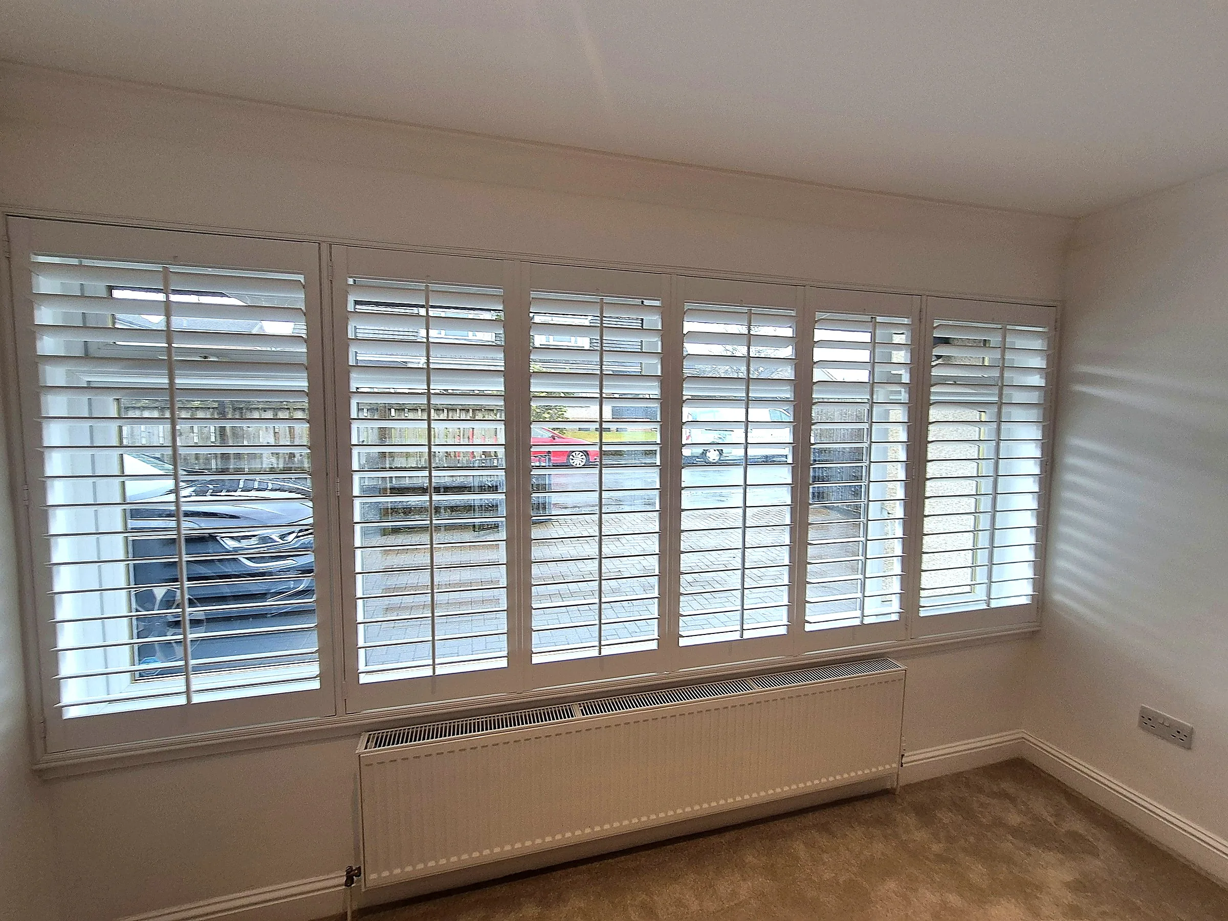Full height shutters fitted across a wide window