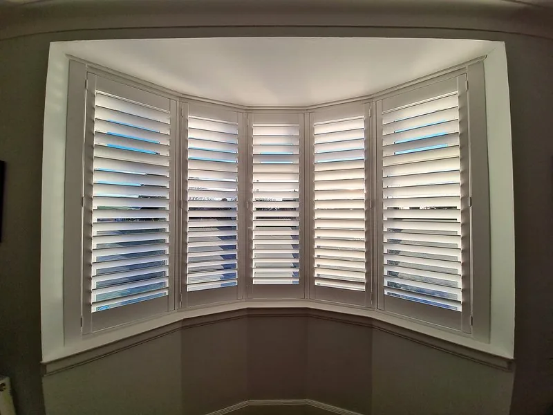 White full height shutters on a bay window
