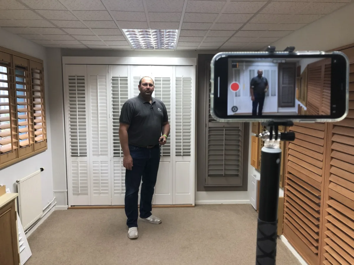 David D'Ambrosio on a video call, showing shutters in the Design Studio to a customer on camera