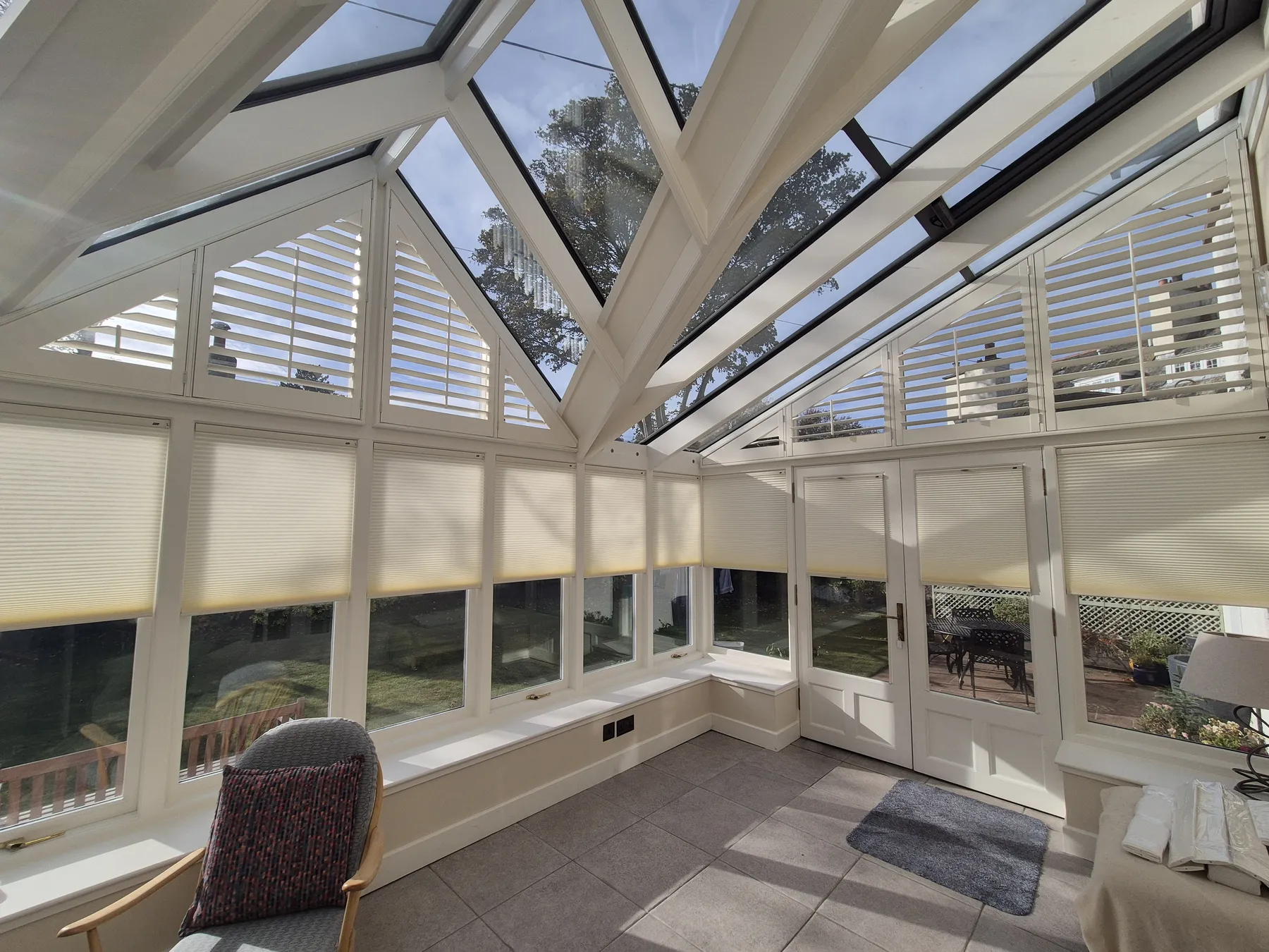 White conservatory with Duette cellular blinds fitted to side windows and glass roof