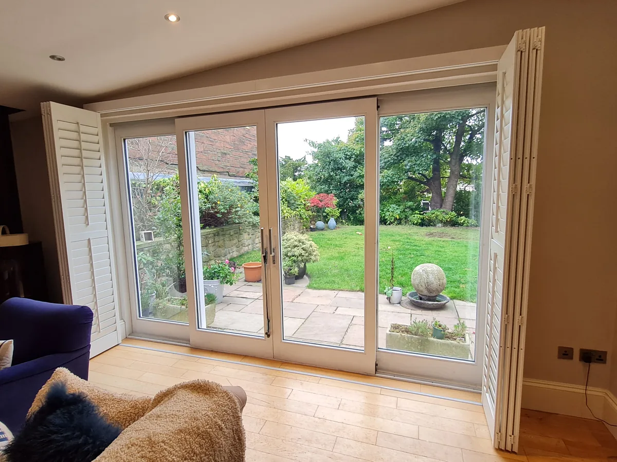 Tracked patio-door shutters folded back showing the doors clear for use