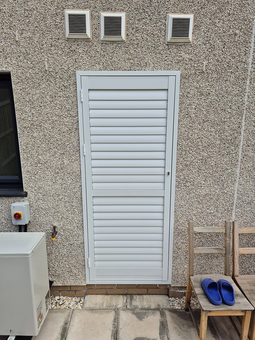 Portchester external aluminium shutters fitted externally over a doorway on a rendered wall