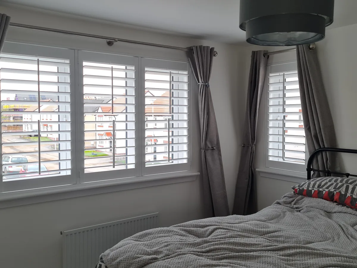 Full height shutters with horizontal slats in a bedroom