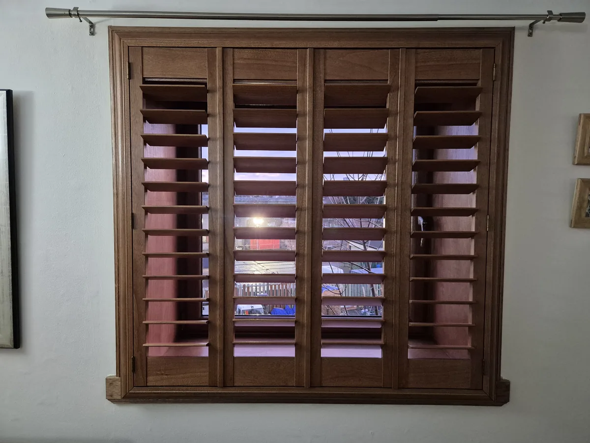 Dark-stained wooden full height shutters in a Scottish interior